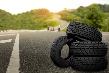 Black rubber tyre set with curve on the hill is background.Safe travel ideas with the best tires clipart