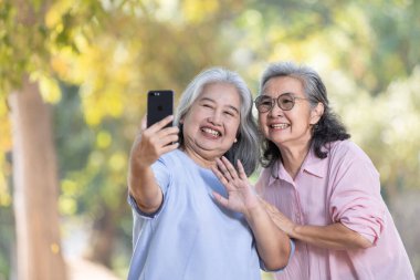 Üst düzey Asyalı çift cep telefonuyla selfie çekiyor.