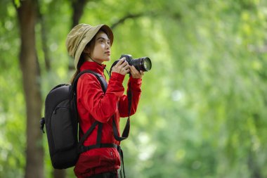 Kırmızı Ceketli Fotoğrafçı Yeşil Ormandaki Kamerayla Doğanın Güzelliğini Yakalıyor