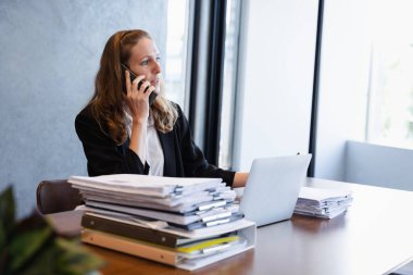 Odaklanmış İş Kadınları Raporları İnceleme ve Profesyonel Ofiste Bir Telefon Görüşmesi Yapma
