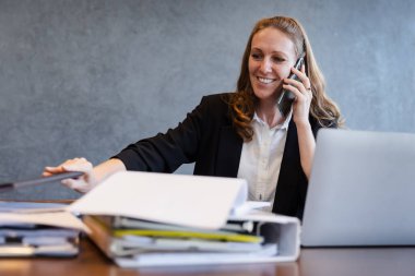 Odaklanmış İş Kadınları Raporları İnceleme ve Profesyonel Ofiste Bir Telefon Görüşmesi Yapma