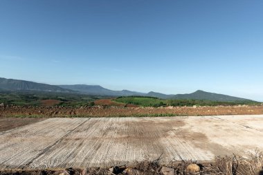 Dağları olan beton yolun yan görüntüsü.