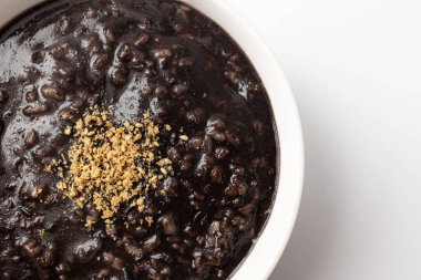 Beyaz arkaplanda beş tahıllı siyah susam lapası.