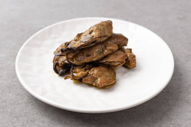 Tütsülenmiş istiridye tütsülenmiş ve zeytinyağında marine edilmiş.