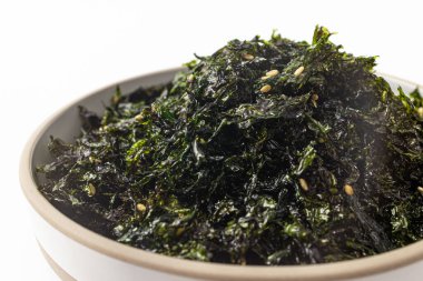 Beyaz bir arka planda baharatlı, kurutulmuş ve ızgara deniz yosunu.