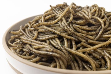 Beyaz arka planda mürekkep balığı soslu makarna.