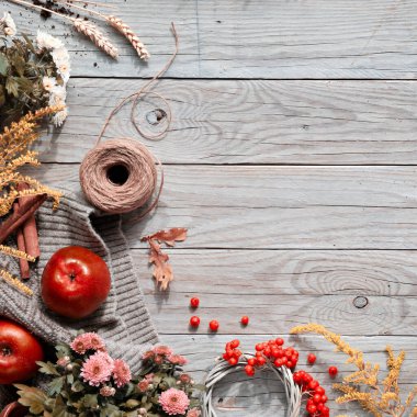 Turuncu Hokkaido kabağı, rowan üzümü, elma, tarçın. Eski ahşap üzerinde sonbahar dekoru. Düz konum, üst görünüm, kare sonbahar sezonu arkaplanı kopya alanı, eski masadaki metin için yer..