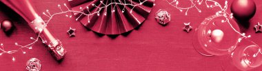 Yılbaşı sofrası. Yaşasın 2023 'ün Magenta rengi. Renkli tek renkli görüntü. Tabaklar, altın kaplar ve altın kağıt yelpaze, incik boncuklar ve çelenkler. Düz, tekstil masa örtüsünün üstü..