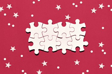 2023 yılının Viva Magenta renginde kırmızı arkaplanın ortasındaki bulmaca parçaları. Kar taneleri ve yıldızlı Noel arkaplanı. Noel kış soyut şenlik arka planı, fotokopi alanı.