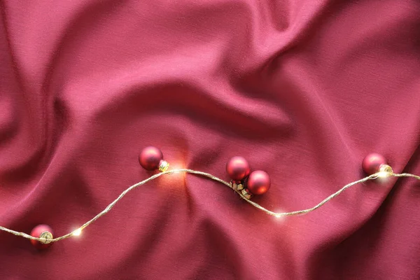 2023年的Viva Magenta颜色 深红色的圣诞背景 红色丝织品衬托下的单色平面装饰着圣诞彩灯和彩灯花环 — 图库照片