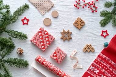 Kutsanmış Noel, Noel, Letonya kış festivali. Letonya 'dan gelen etnografik semboller ve desenler, ahşap tılsımlar, ambalaj kağıtları, köknar dalları ve böğürtlenlerle hediye kutuları. Baltık mevsimsel desenleri kırmızı.