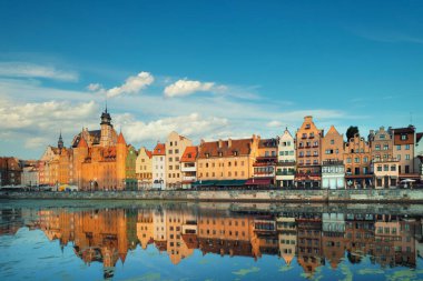 Gdansk 'ın mavi gökyüzünün altında bulutlarla yansıması olan şehir manzarası.