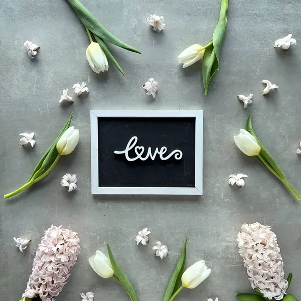 Весенние Цветы Тюльпана Гиацинтовые Цветы Окружающие Доску Словом Любовь Написанным — стоковое фото