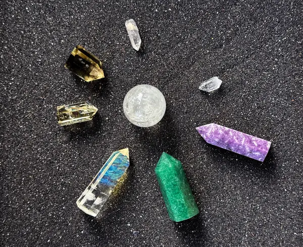 stock image Colorful Crystals and Gemstones Arranged on Black Sand Background in Circular Pattern.