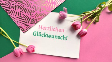 İspanyolca yazılı tebrik kartı Un pequeo detalle para ti sizin için küçük bir detay, pembe, yeşil ve kırmızı tonlu, lalelerle süslenmiş geometrik bir arkaplan.