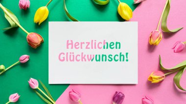 İspanyolca yazılı tebrik kartı Un pequeo detalle para ti sizin için küçük bir detay, pembe, yeşil ve kırmızı tonlu, lalelerle süslenmiş geometrik bir arkaplan.