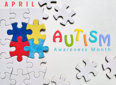 Otizm Farkındalığı Ayı konsepti otizmin farkındalığını sembolize eden renkli yapboz parçalarını içeriyor. Beyaz arkaplan üzerinde 