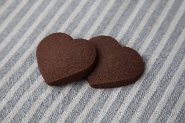 Kalp şeklinde çikolatalı kurabiyeler. Masa örtüsünde izole edilmiş.