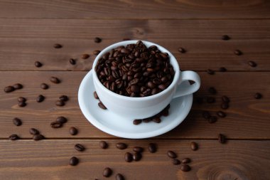 roasted coffee beans in coffee cup closeup on table