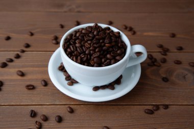 roasted coffee beans in coffee cup closeup on table