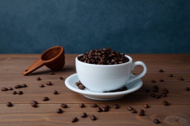 roasted coffee beans in coffee cup closeup on table