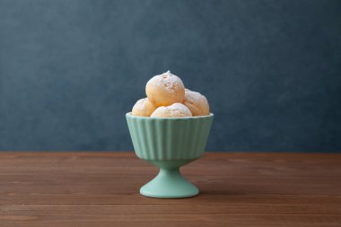 Kremalı puf, yakın plan, ahşap masada izole.