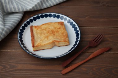 Kapalı tabakta yumurtalı ekmek. Masada izole.