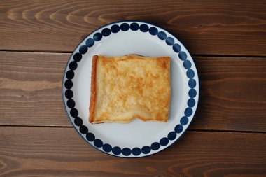 Kapalı tabakta yumurtalı ekmek. Masada izole.