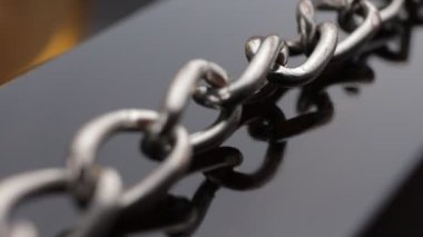 Close up of metal chain links conveying the message of power or entrapment