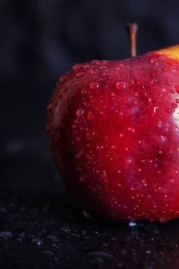 Siyah arka planda çiğ tanecikli kırmızı elma