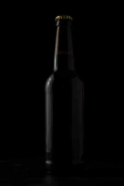 A bottle of beer on a black background.