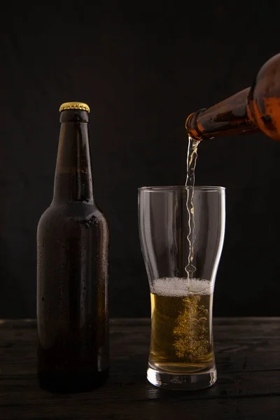 Pouring beer into a glass on a black background
