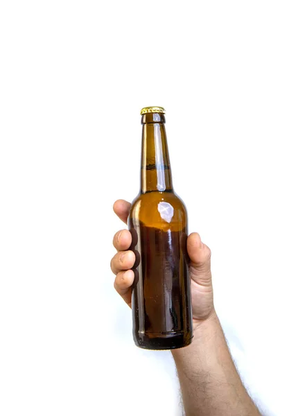 Beer bottle in hand isolated on white