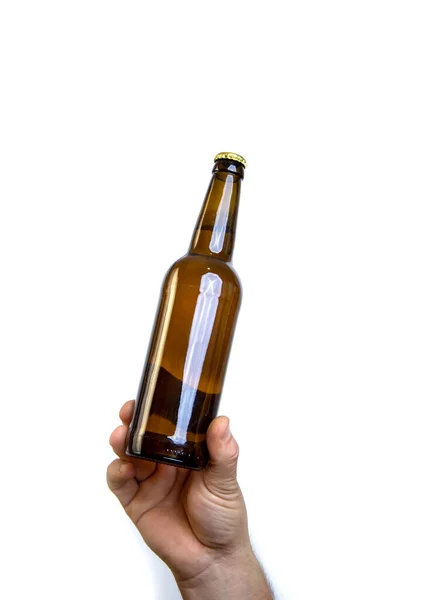 Beer bottle in hand isolated on white