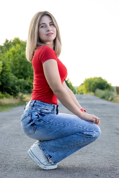 Blonde in jeans on the road.