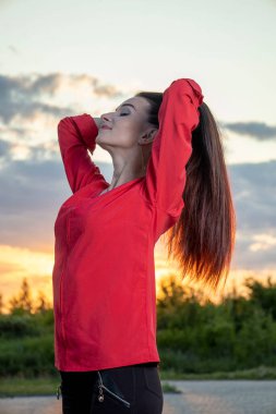 Günbatımının arka planında güzel bir genç kız.