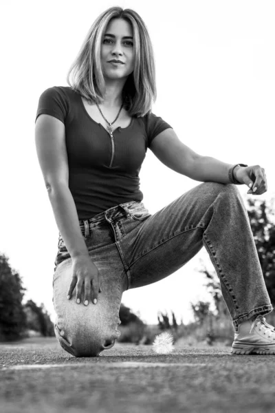 Blonde in jeans on the road.