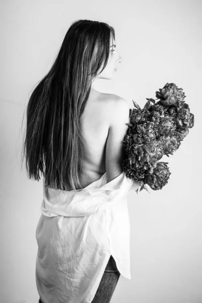 Een Meisje Met Bloemen Een Wit Shirt Bij Muur — Stockfoto