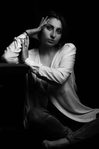Siyah arka planda genç bir kızın siyah beyaz fotoğrafı.