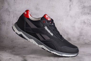 Kyiv, Ukrayna - 5 Eylül 2023: Gri arka planda Reebok gri spor ayakkabıları