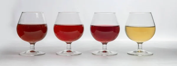 Different types of wine in glasses on a white background.