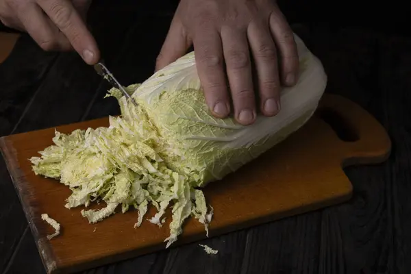 Cutting vegetables. Male hands cutting cabbage on a cutting board