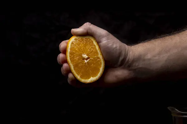 Cut squeezed orange in hand.