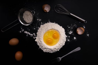 Siyah üzerine yumurta, un ve çatal bıçak..