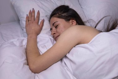 Kız beyaz bir yatakta uyuyor..