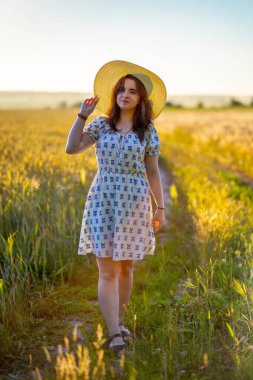 Güneş ışınlarının arka planında şapkalı bir kız.