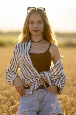 Güneşin altında buğday tarlasında güzel bir Ukraynalı kız.