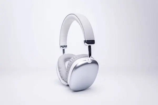 Şık gümüş ve beyaz kablosuz kulaklıklar müzik dinlemeye ya da çağrılara cevap vermeye hazır.