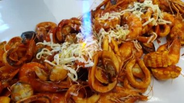 Deniz ürünleri kovası, cajun bbq soslu peynir, karides, kalamar, misket tüfeği ve midye.