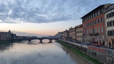 Florence Italy 'nin nehir üzerindeki gün batımı manzarası. Yavaş çekim video köprüleri ve panoramik güzel mimari